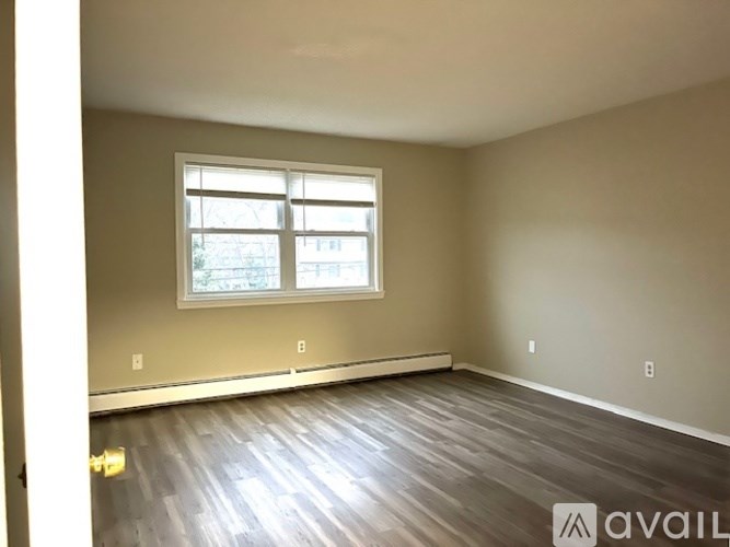 A room with a window and wooden flooring is available for rent.