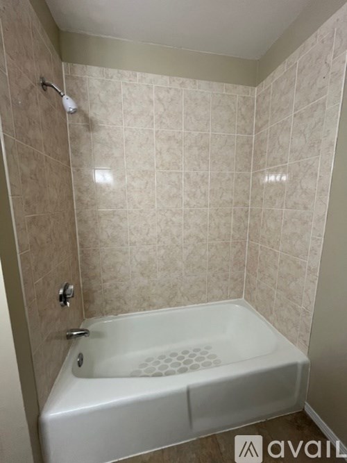 A white bathtub with a shower head and a shower head.