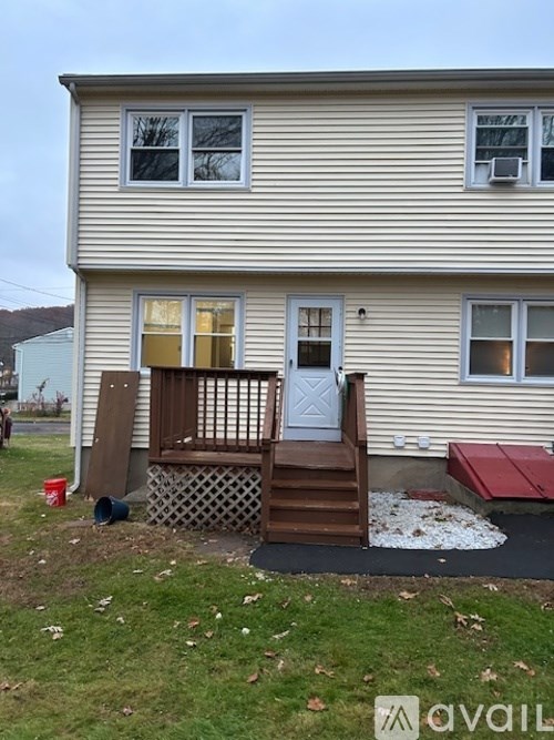 A house with a red awning and a wooden deck.