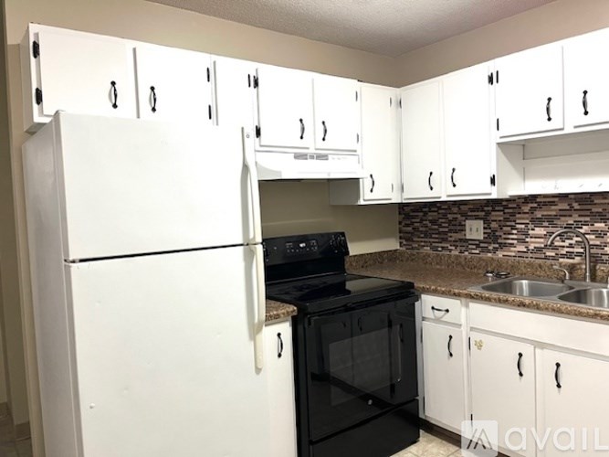 A kitchen with white cabinets and a black oven.