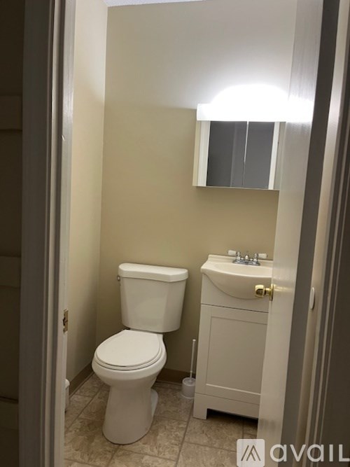 A white toilet and sink in a small bathroom.