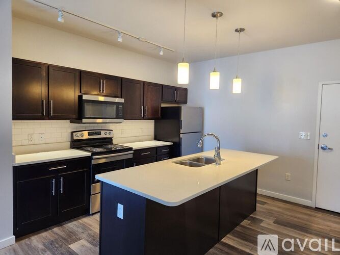 A kitchen with black cabinets and a white countertop.