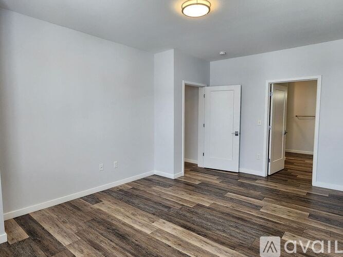 A room with wood flooring and two white doors.