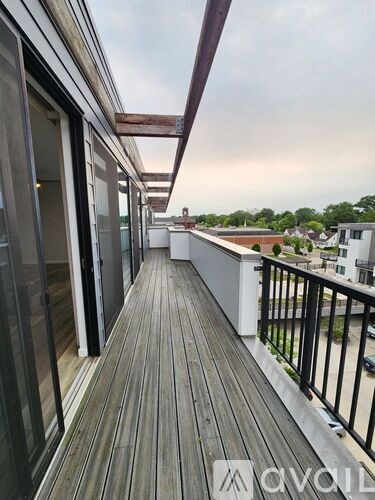 A balcony with a wooden floor and black railings.