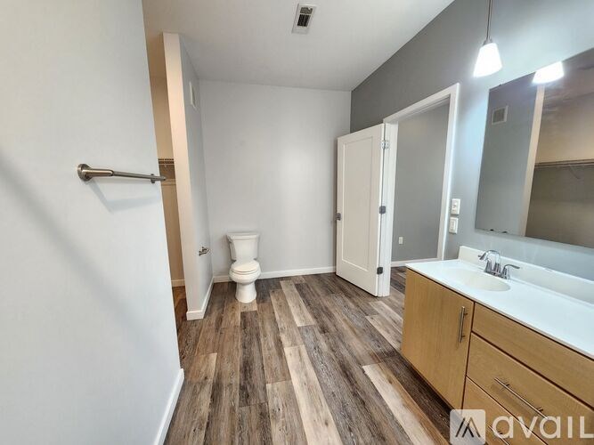 A bathroom with a toilet, sink, and mirror.
