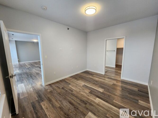A room with wooden flooring and white walls is available for rent.