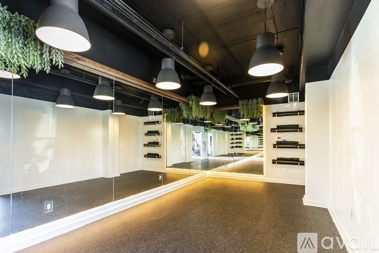 A spacious room with a long hallway and a plant hanging from the ceiling.