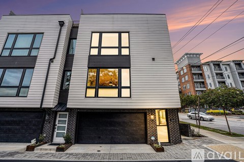 A modern two-story house with a garage and a brick wall.