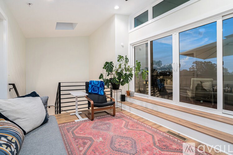 A room with a bed, a chair, and a potted plant.