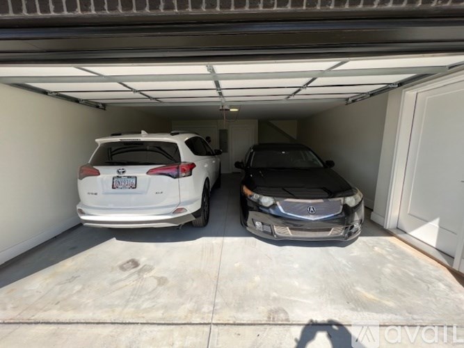 Two cars are parked in a garage.