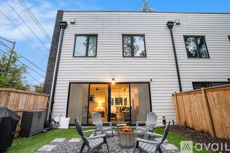 A house with a patio and chairs in front of it.