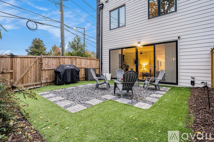 A backyard with a patio and lawn.