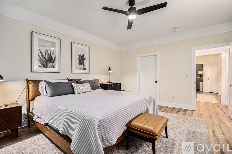 A bedroom with a large bed and a ceiling fan.