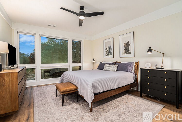 A bedroom with a bed, dresser, and window.