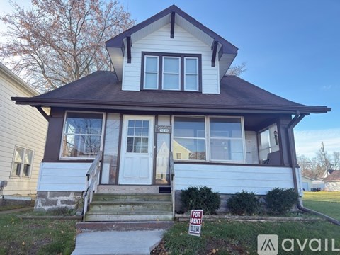 A house with a for sale sign in front of it.