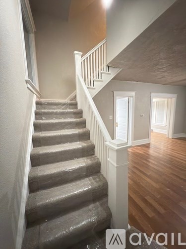 A staircase with a wooden floor and white railings.
