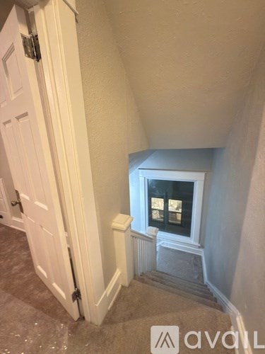 A white door is open to a stairway.