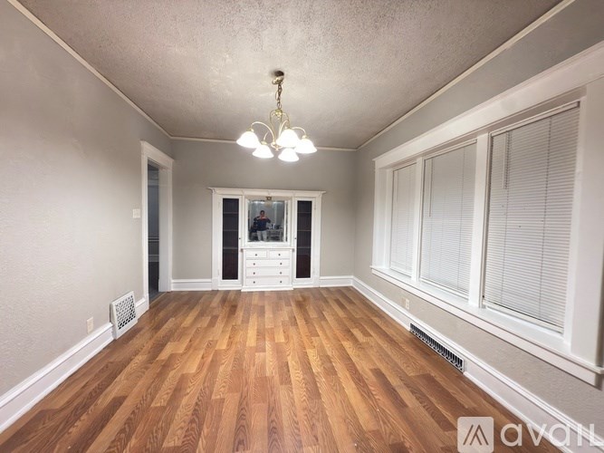 A room with wooden floors and a chandelier.