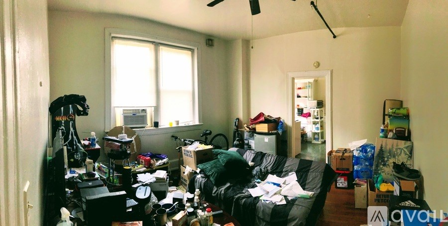 A room with a lot of clutter and boxes scattered about.