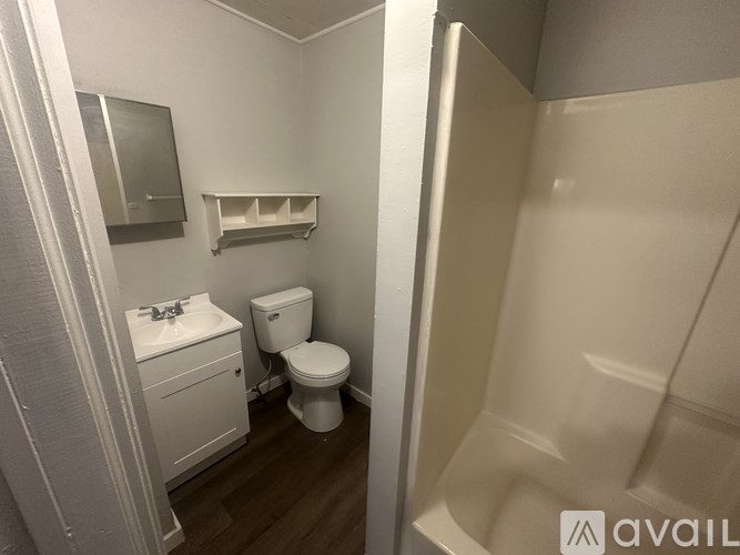 A small bathroom with a toilet, sink, and a shower stall.