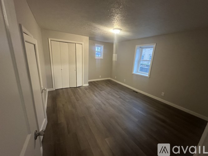 A room with wooden flooring and a window.