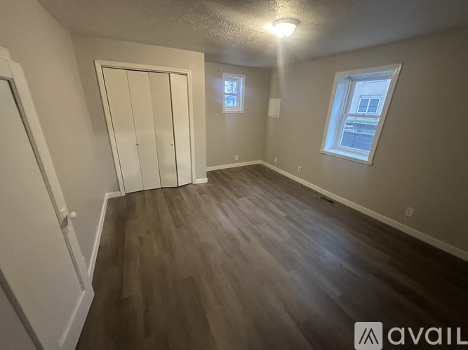 A room with wooden flooring and a window.