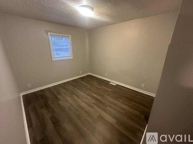 A room with wooden flooring and a window.