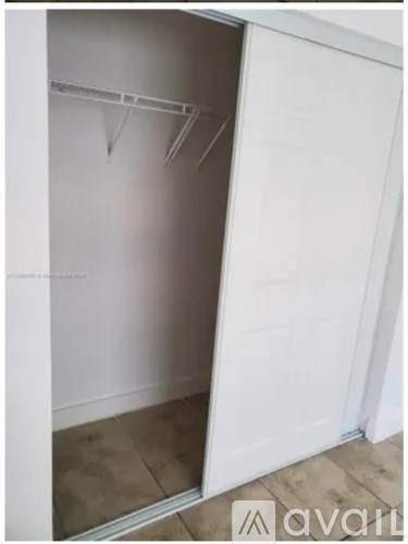 A white closet with a hanger on the left side.