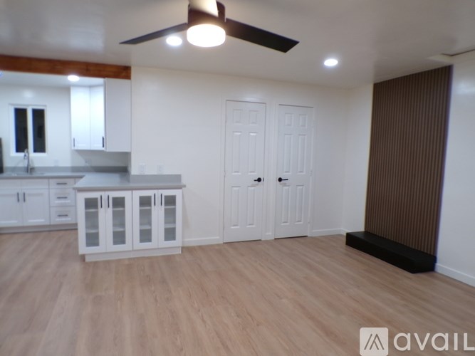 A room with a kitchen area and a dining table.