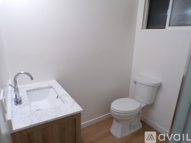 A white toilet sits next to a sink in a bathroom.
