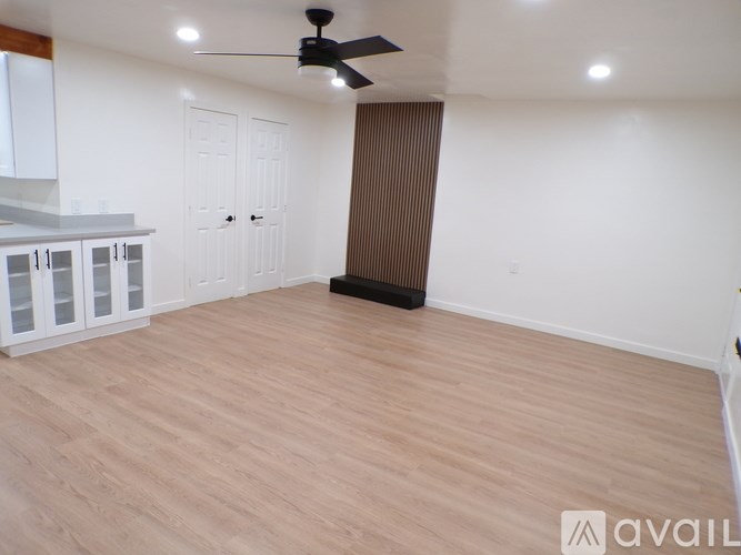A room with a ceiling fan and wooden flooring.