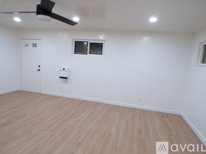 A room with a ceiling fan and a door.