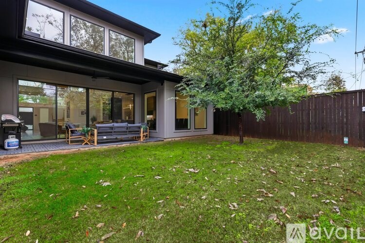 A modern house with a backyard and a tree.