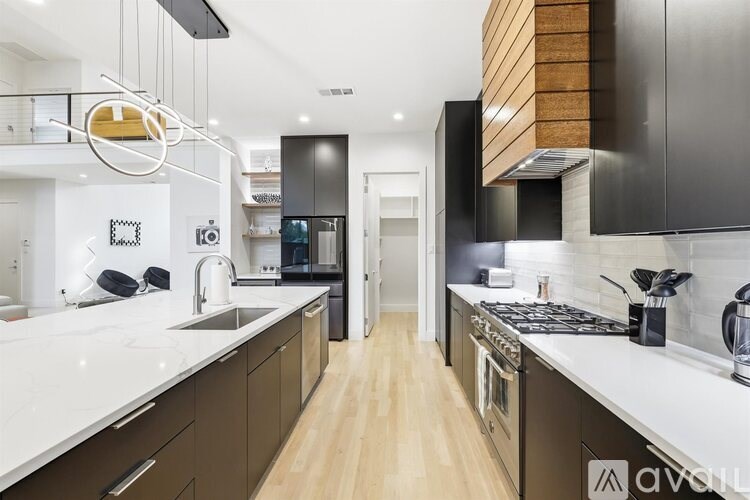 A modern kitchen with dark brown cabinets and white countertops.