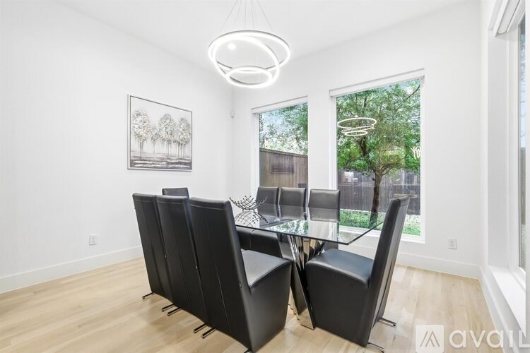 A modern dining room with a glass table and chairs.