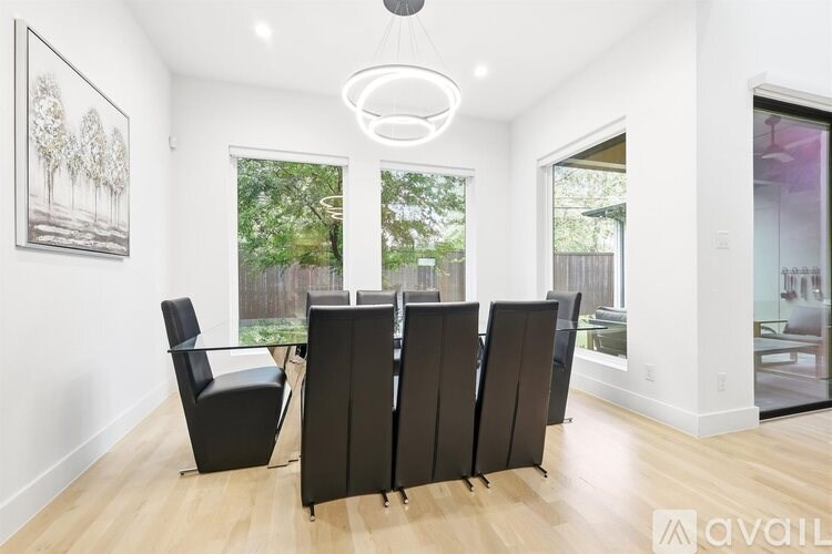 A living room with a black chair and a framed picture on the wall.