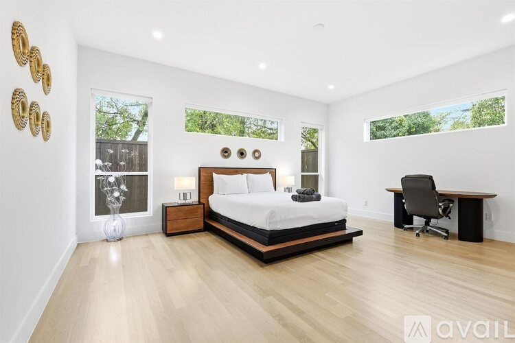 A bedroom with a large bed, a desk, and a chair.