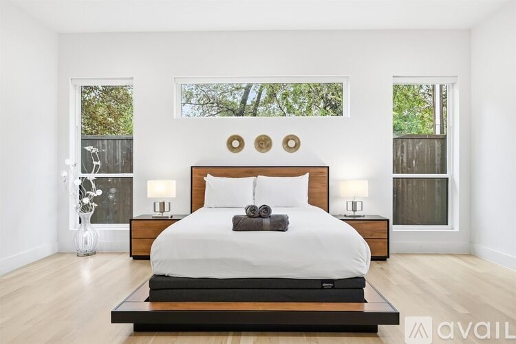 A bedroom with a large bed and a wooden headboard.