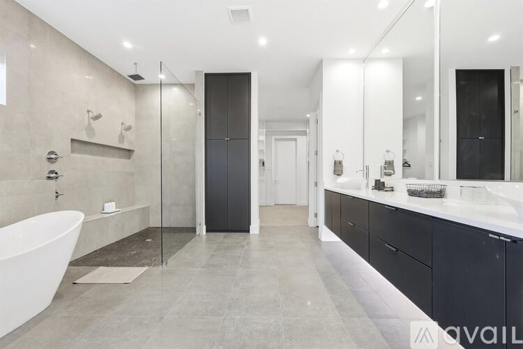 A modern bathroom with a white bathtub and a walk-in shower.