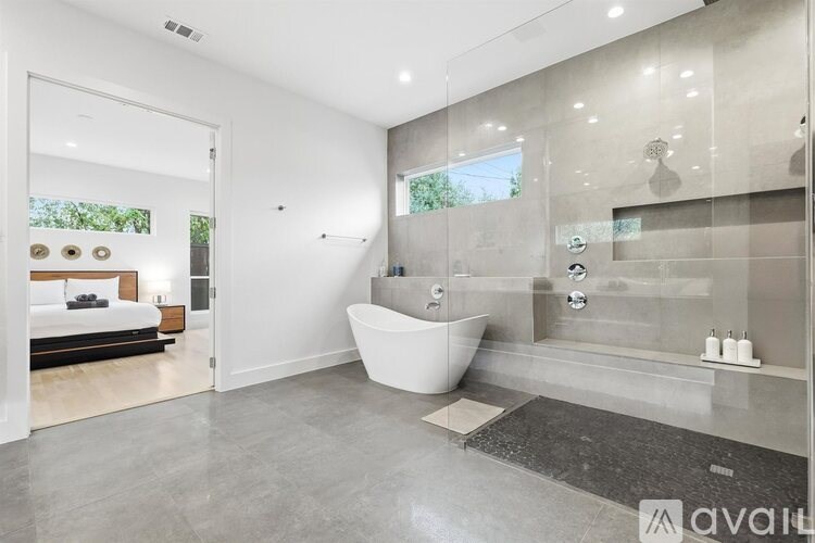 A modern bathroom with a large tub and a walk-in shower.