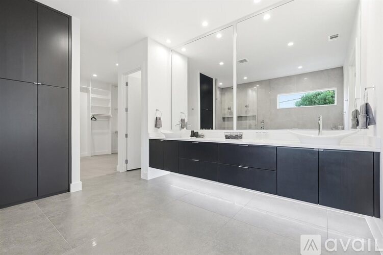 A modern bathroom with a large mirror and a sink.
