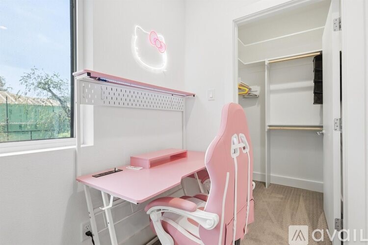 A pink chair is in front of a desk with a pink box on it.
