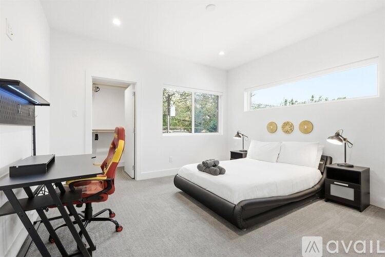 A bedroom with a bed, desk, and chair.