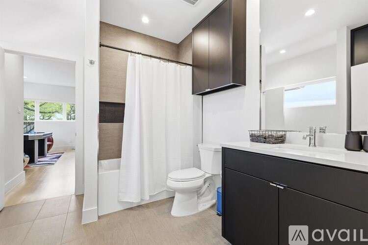 A bathroom with a toilet, sink, and shower.