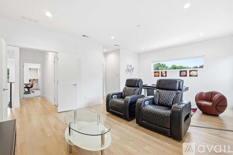 A living room with a glass table and leather chairs.