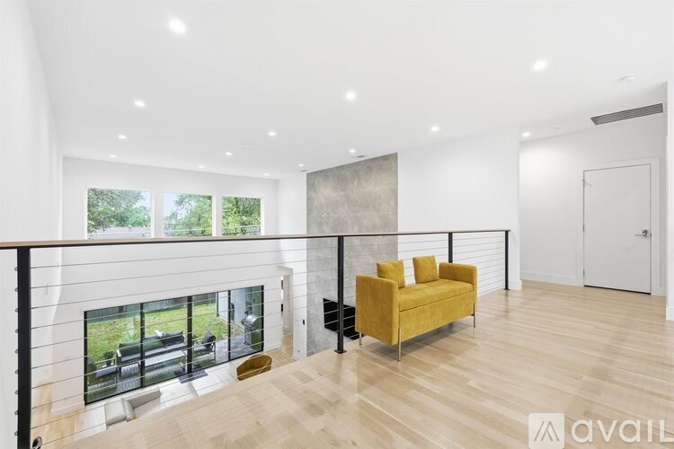 A living room with a yellow sofa and a fireplace.