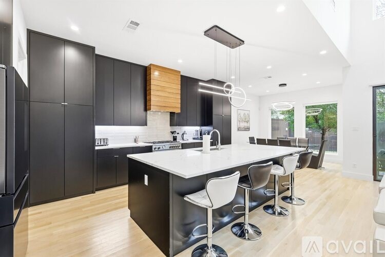 A modern kitchen with black cabinets and white countertops.