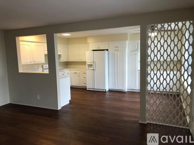 A kitchen with white cabinets and a white refrigerator.