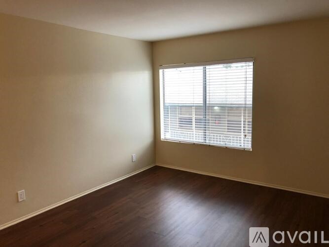 A room with a window and wooden flooring is available for rent.