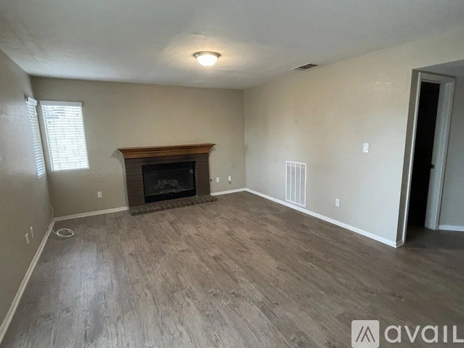 A living room with a fireplace and wood flooring.